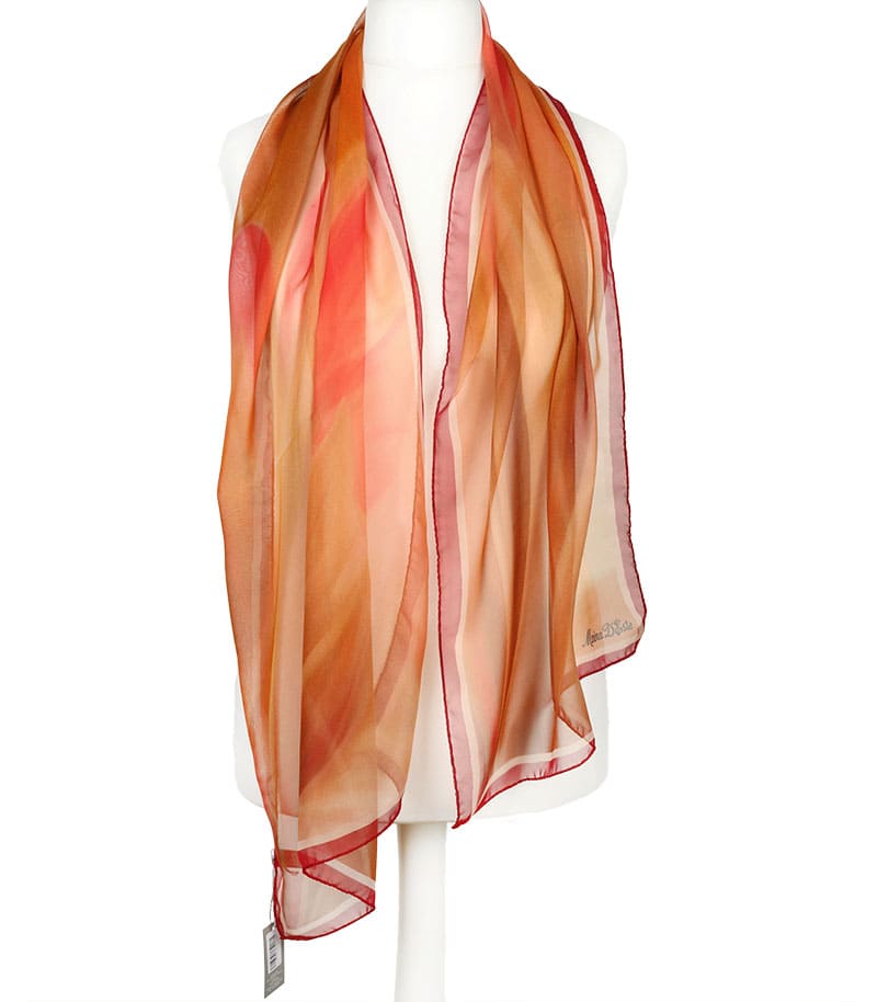 alt="Zwiewny jedwabny szal damski Marina D’Este w ciepłych tonach czerwieni i miedzi"